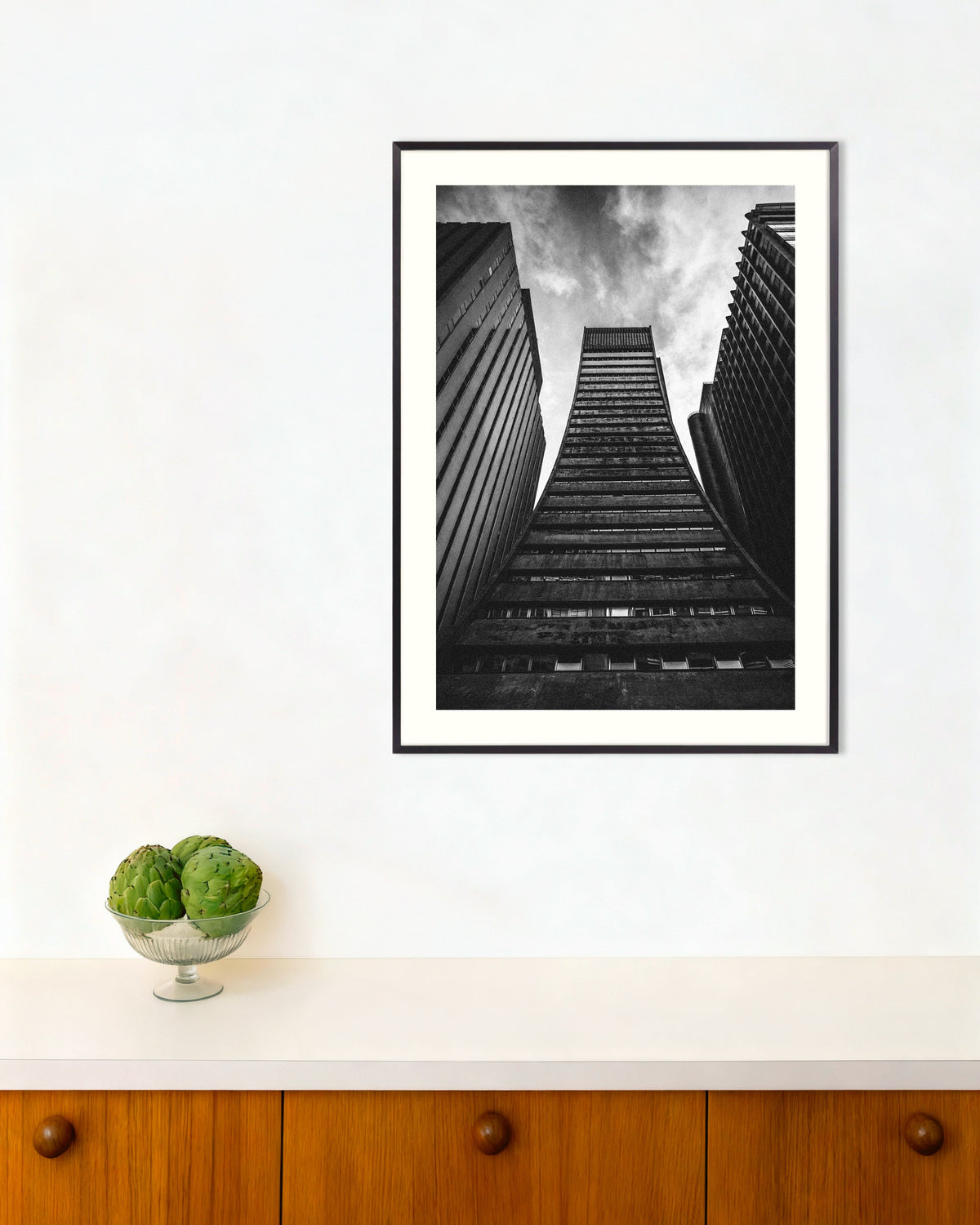 Poster ‘Uitlopende toren tussen reuzen’, met metalen lijst