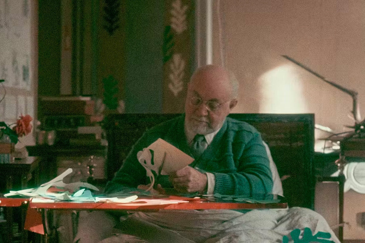 Henri Matisse op hoge leeftijd, aan zijn tafel vormen knippend uit beschilderd papier