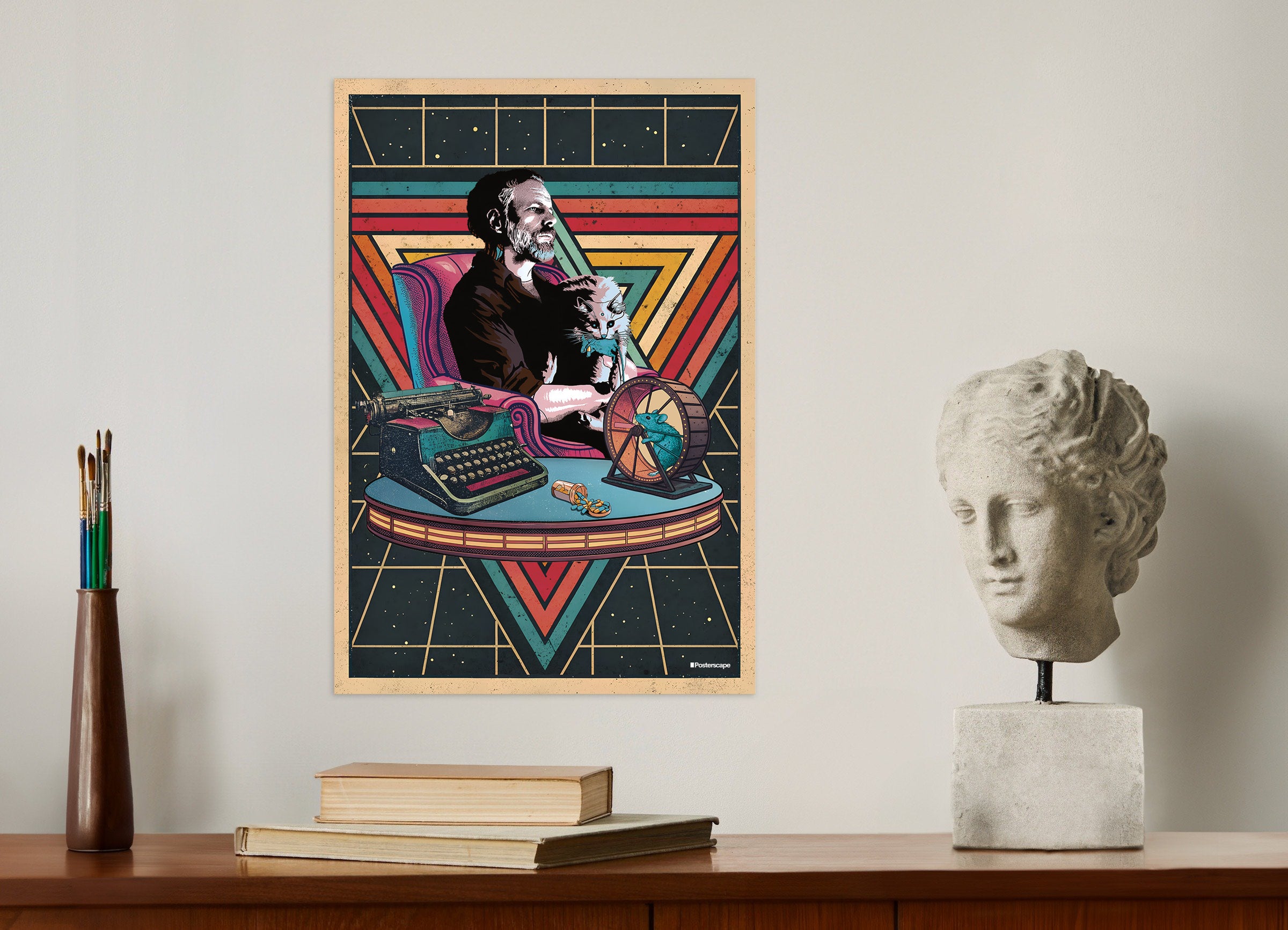 Colorful poster of the writer Philip K. Dick with a cat on a typewriter, placed on a wall above a desk with books and a sculpture.