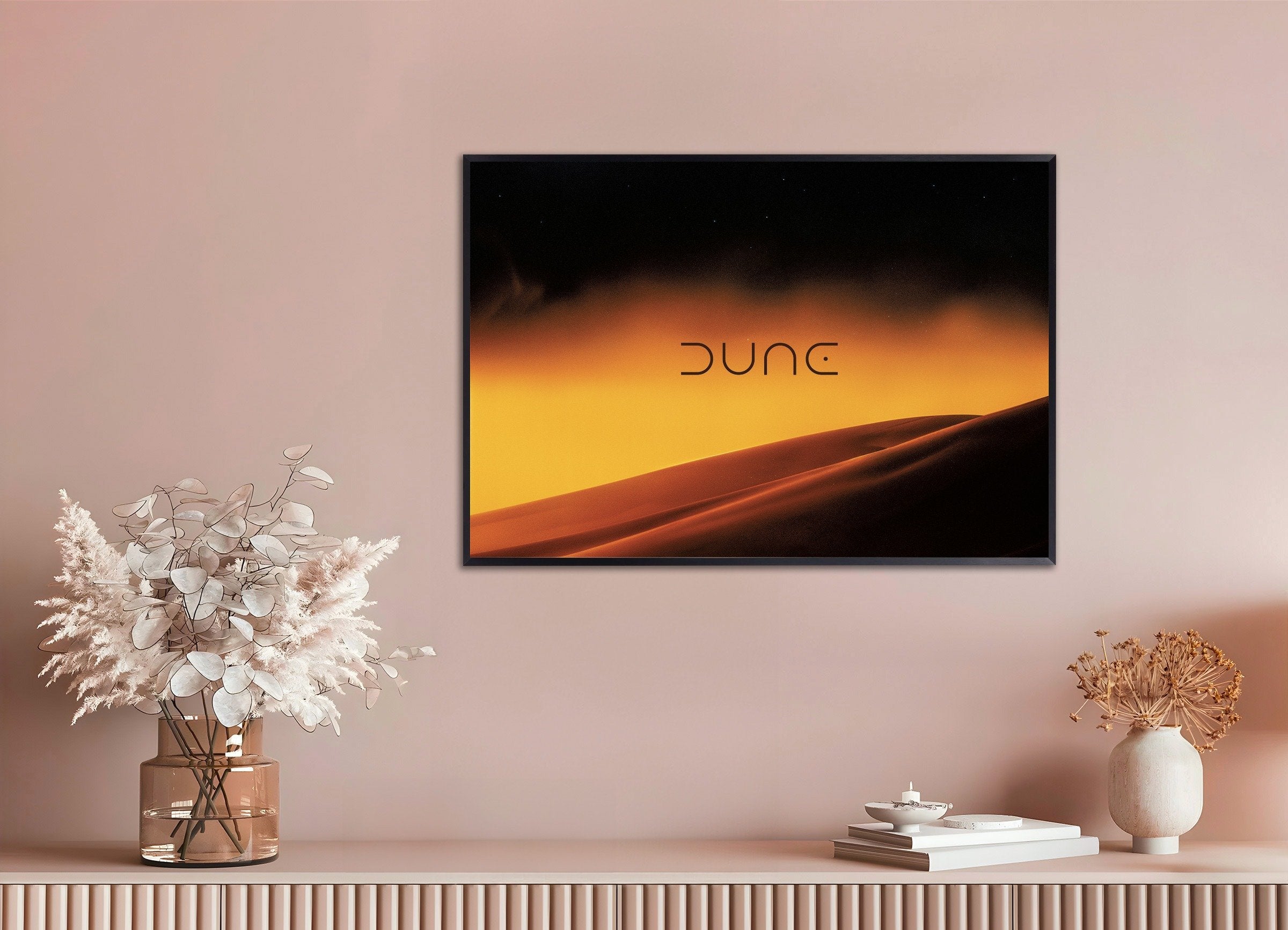 TV displaying 'Dune' on a wall with decorative items below